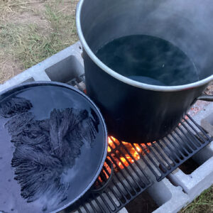 Multiple dye vats with different colors in an outdoor setting.