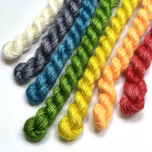 A bright collection of multicolored yarns arranged in a row, emphasizing a range of textures and hues.