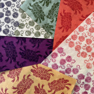 Assorted handprinted fabrics featuring wool and grape motifs in multiple colors.