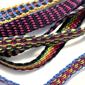 A collection of intricately braided and woven colorful cords, displayed on a flat surface.