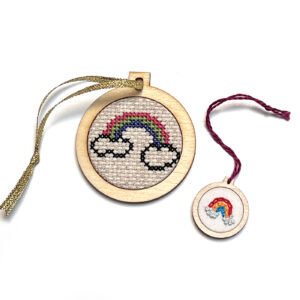 Two cross-stitch kits featuring cloud and rainbow designs, one large and one small, on wooden hoops.